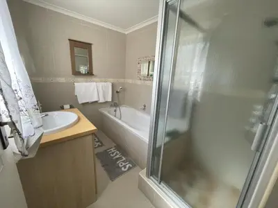 a bathroom with a shower and a tub and a sink at Marshrose Accommodation in Bellville