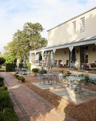 a patio with tables and chairs in front of a building at Pontac Manor Hotel & Restaurant in Paarl