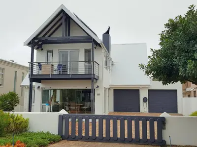 a house with a black fence in front of it at Charming Fisante house in Hermanus