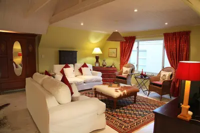 a living room with two white couches and a table at Charming Fisante house in Hermanus