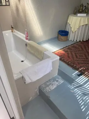 a bathroom with a white sink and a table at Dancers' Cottages in Cape Town