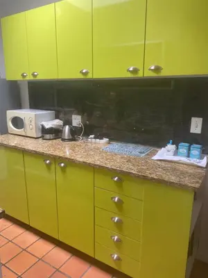 a kitchen with green cabinets and a counter top at Dancers' Cottages in Cape Town