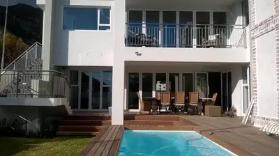 a house with a swimming pool and a balcony at Cape Coral in Hermanus