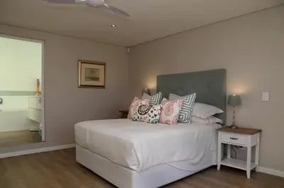 a bedroom with a white bed with pillows on it at Cape Coral in Hermanus