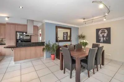 a dining room and kitchen with a table and chairs at Atlantic Breeze in Cape Town