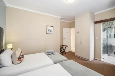 a hotel room with two beds and a bathroom at Atlantic Breeze in Cape Town