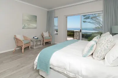 a bedroom with a bed and a view of the ocean at On The Rocks in Hermanus