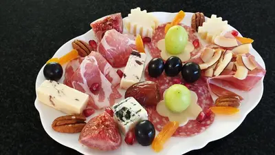 a plate of different types of cheese and fruit at Villa Adalbert Guesthouse in Somerset West