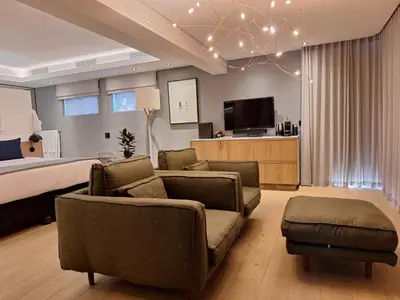 a bedroom with a bed and a couch and a tv at Clouds Estate in Stellenbosch