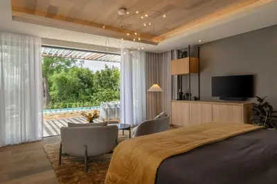 a bedroom with a bed and a tv and a living room at Clouds Estate in Stellenbosch
