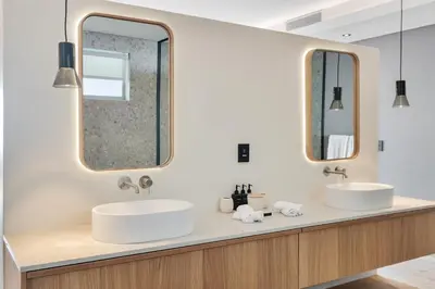 two sinks in a bathroom with two mirrors at Clouds Estate in Stellenbosch