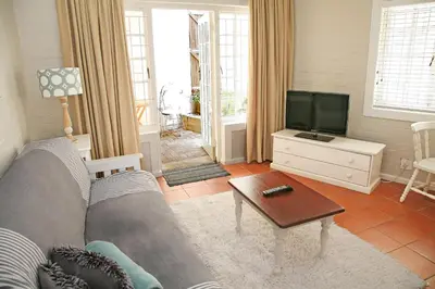 a living room with a couch and a tv at The Winelands Guest House in Bellville