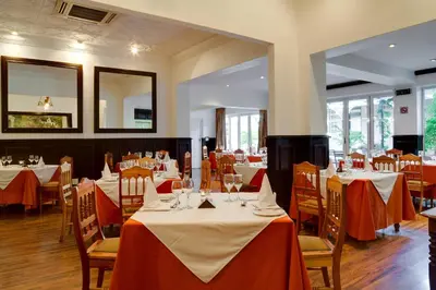 a restaurant with tables and chairs with red and white tablecloths at Protea Hotel by Marriott Dorpshuis & Spa Stellenbosch in Stellenbosch
