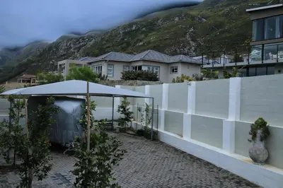 a white fence with a tent in front of some houses at Eagleview Guesthouse in Hermanus