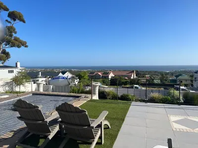 a patio with two chairs and a swimming pool at Eagleview Guesthouse in Hermanus