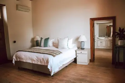 a bedroom with a large bed and a mirror at Andreas Country House in Wellington