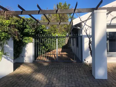 an entrance to a house with a metal gate at Two Vines Romantic Guest Studio in Stellenbosch