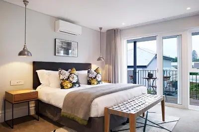 a bedroom with a large bed and a balcony at Bonne Esperance Boutique Guest House in Stellenbosch
