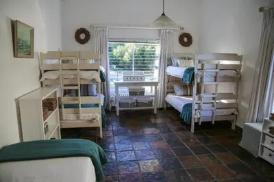 a room with several bunk beds and a window at Brander View in Hermanus