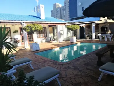 a swimming pool in the middle of a building at Dolphin Inn Blouberg in Bloubergstrand