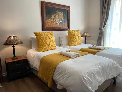 two beds sitting next to each other in a bedroom at Hoogeind Manor in Somerset West