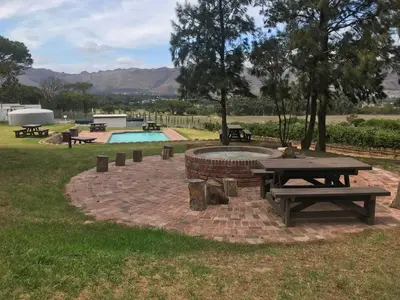 a park with a picnic table and a pool at Hoogeind Manor in Somerset West
