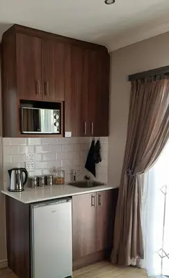 a kitchen with wooden cabinets and a sink and a dishwasher at Panorama Self Catering in Panorama
