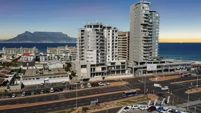 a city with two tall buildings next to the ocean at Aquarius Luxury Suites in Bloubergstrand