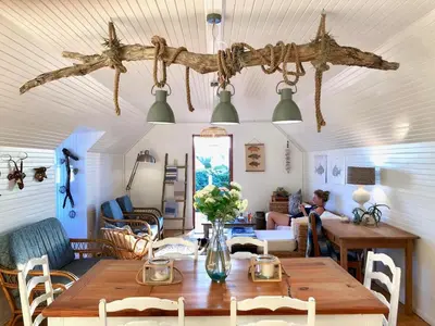 a living room with a wooden table and chairs at Renovated Fishermans Cottage in Hermanus