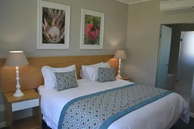 a bedroom with a large white bed with pillows at Pearl Valley Suites in Simondium