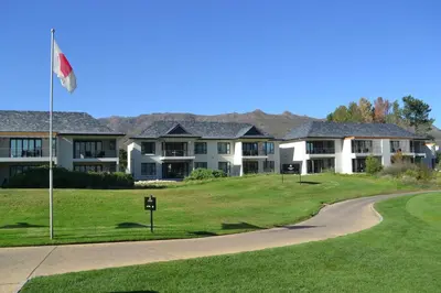 a house on a golf course with a flag at Pearl Valley Suites in Simondium