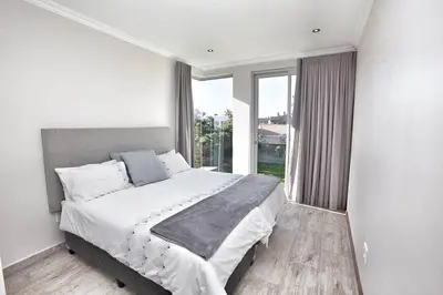 a bedroom with a large bed and a large window at Lamabeach city farm in Cape Town