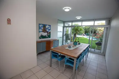 a dining room with a wooden table and blue chairs at Lamabeach city farm in Cape Town