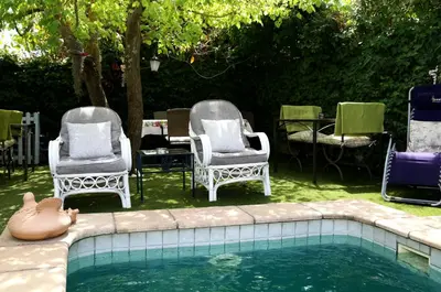 a couple of chairs and a swimming pool at Centre-Ville Guest House in Franschhoek