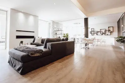 a living room with a couch and a dining room at Boschenmeer House in Paarl