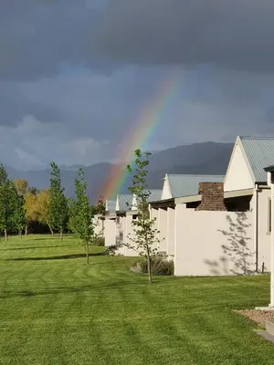 a rainbow over a house with a yard at Paddabult Self Catering Cottages in Paarl