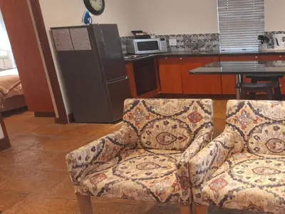 a living room with a couch and a kitchen at Paddabult Self Catering Cottages in Paarl