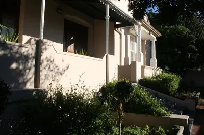 a white house with a window and some bushes at Glen Lilly Self Catering in Parow