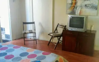 a bedroom with a tv and a chair and a bed at Glen Lilly Self Catering in Parow