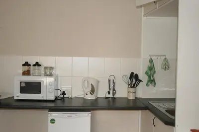 a kitchen counter with a microwave and utensils at N-One Self Catering in Goodwood