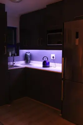 a kitchen with black cabinets and a blue kettle on the counter at Merci Pére in Gordonʼs Bay
