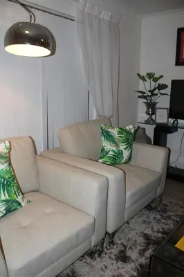 a couch and a chair in a living room at Merci Pére in Gordonʼs Bay