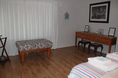 a room with a table and a bench and a desk at Merci Pére in Gordonʼs Bay