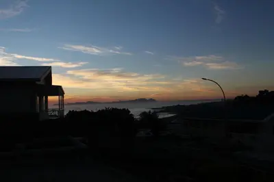 a view of the sunset from a building with a street light at Merci Pére in Gordonʼs Bay