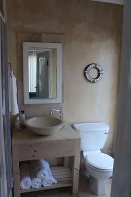 a bathroom with a sink and a toilet and a mirror at Akwa in Hermanus