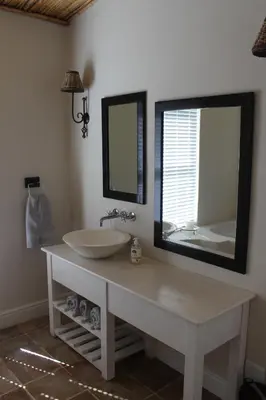 a bathroom with a sink and a large mirror at Akwa in Hermanus