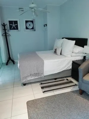 a bedroom with a bed and a blue wall at The Palm in Pinelands in Cape Town
