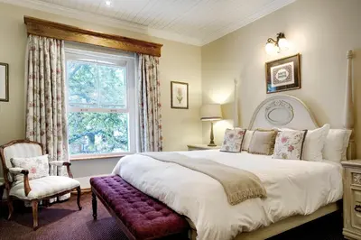 a bedroom with a large bed and a window at Coopmanhuijs Boutique Hotel & Spa in Stellenbosch
