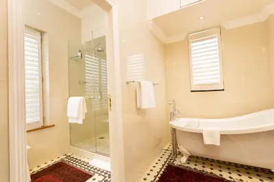 a bathroom with a tub and a sink and a shower at Coopmanhuijs Boutique Hotel & Spa in Stellenbosch