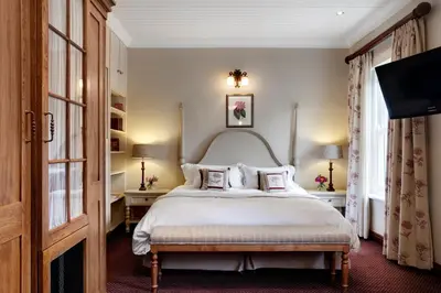 a bedroom with a large bed with white sheets and pillows at Coopmanhuijs Boutique Hotel & Spa in Stellenbosch